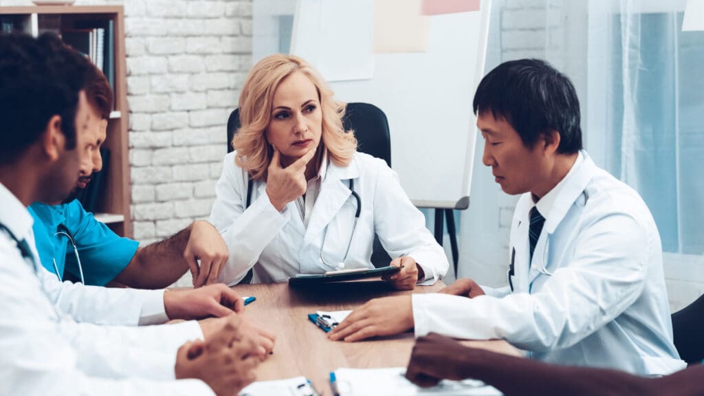 Doctors having a meeting around a table.